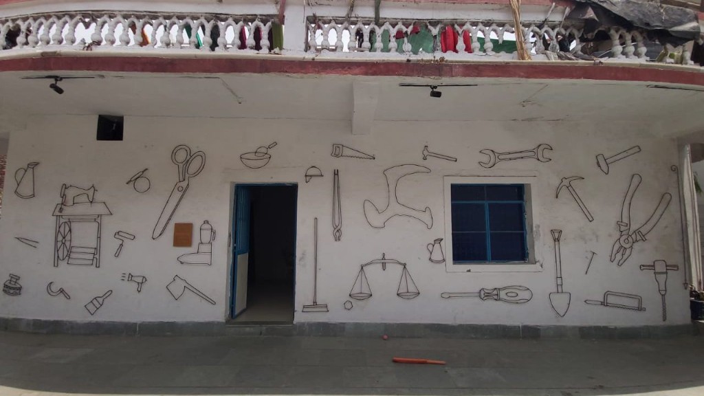 Entrance of Mehnat Manzil with tool murals representing worker-led innovation